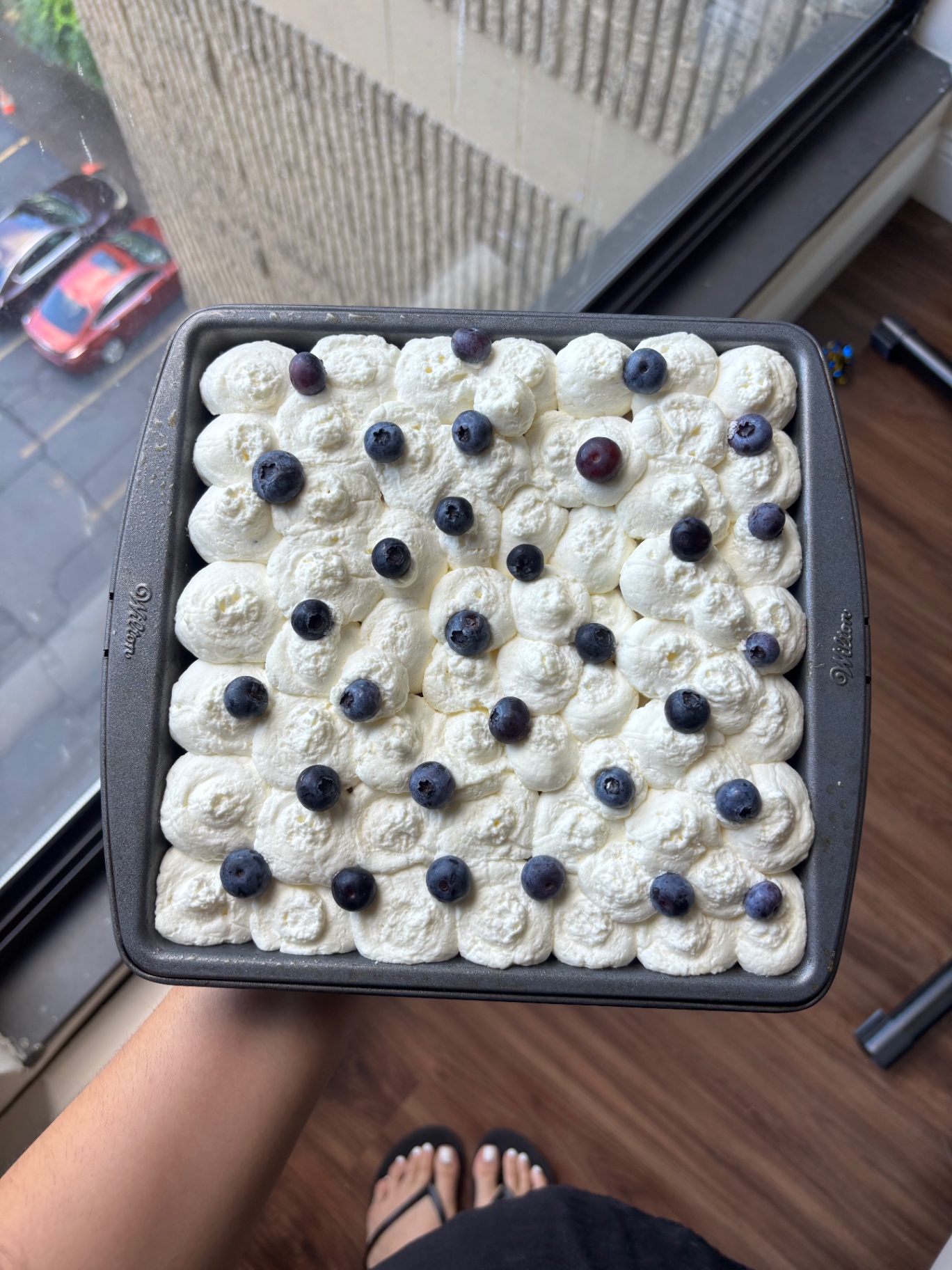 A homemade dessert topped with piped cream and fresh blueberries